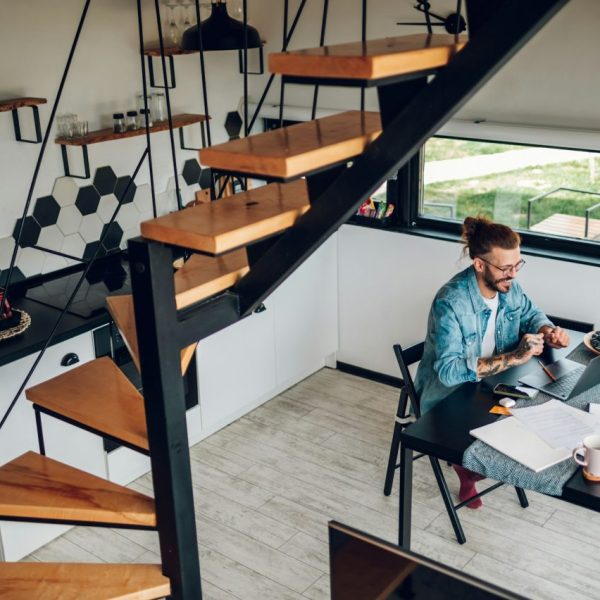 young-business-man-working-at-home-with-laptop-and-papers-on-desk.jpg